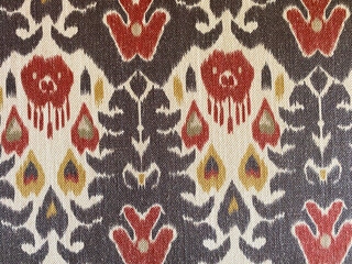 geometric woven ikat pattern in rich brown and red, beautifully contrasting against a crisp white...