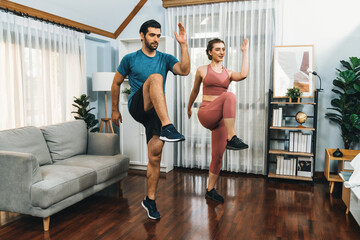 Obraz premium Athletic and sporty fitness couple or exercise buddy running posture at home body workout exercise session for fit physique and healthy sport lifestyle at home. Gaiety home exercise workout training.