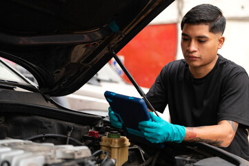 Young latin mechanic fixing a car engine