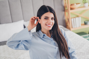 Charming woman in blue pajamas enjoying a morning in her cozy bedroom