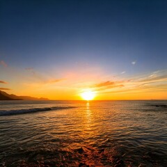 Obraz premium Stunning sunset over a serene ocean, with golden light reflecting on water and a clear sky blending into twilight.