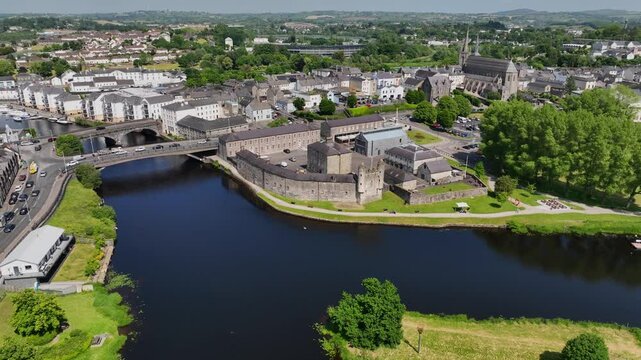 Enniskillen, County Fermanagh, Northern Ireland, June 2023. Drone orbits clockwise in an aerial view of historical landmark museum on the banks of the Erne river near Castle bridge on a sunny day.