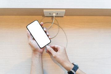 Man hand plug in micro usb cable into blank white screen smartphone to charging phone battery on...