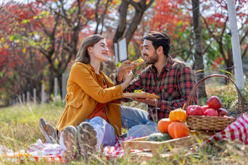 caucasian family having picnic in autumn park,young romantic couple celebrating the autumn harvest together in the wonderful meadow