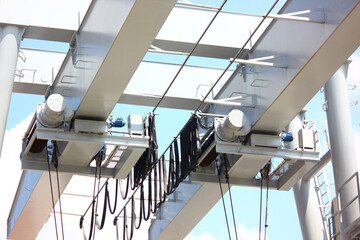 close up low angled shot outdoor two eletric hoists moter set on beam against blue sky