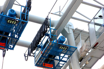 Naklejka premium close up low angled shot outdoor two electric hoists motor set on beam against blue sky