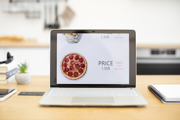 Laptop displaying fast food online sales platform with pizza pricing and discount offer. Modern...