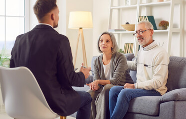 Naklejka premium Consultant or real estate agent is advising a senior couple at home, focusing on insurance, financial planning, investment assistance or estate purchase during the meeting.