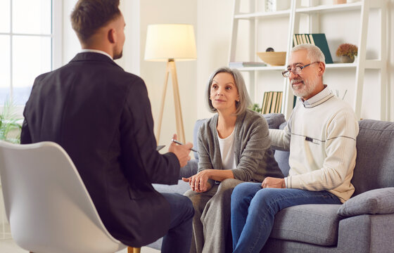 Consultant or real estate agent is advising a senior couple at home, focusing on insurance, financial planning, investment assistance or estate purchase during the meeting.