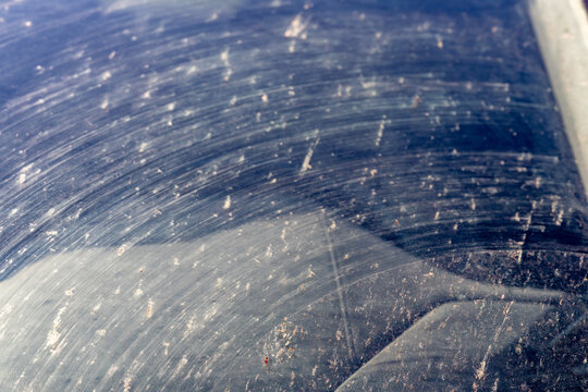 Smeared and dirty front windshield of a vehicle after hitting bugs.