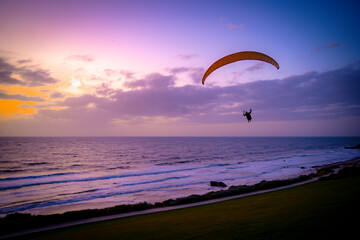 Paragliding on the beach at sunset. 