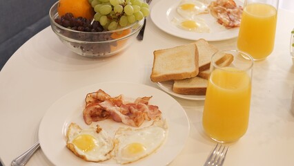 Traditional English breakfast on table with fried eggs and bacon Morning meal showcases classic breakfast elements perfect for food lovers Start day with hearty breakfast featuring delicious flavors
