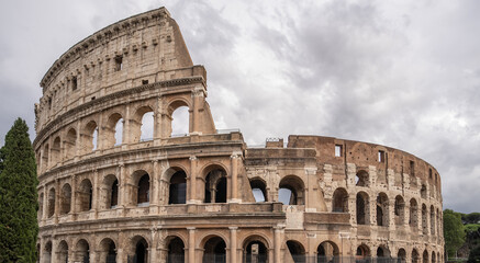Fototapeta premium Arches archictecture of Colosseum (Colosseo) exterior with clouds and sky. Rome, Italy.