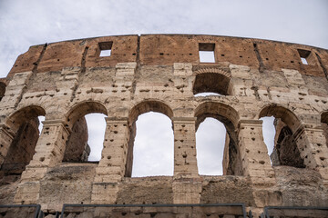 Arches archictecture of Colosseum (Colosseo) exterior with clouds and sky. Rome, Italy.