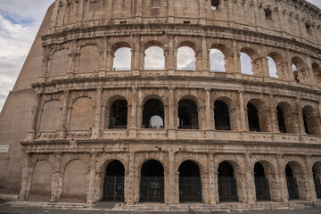 Arches archictecture of Colosseum (Colosseo) exterior with clouds and sky. Rome, Italy.