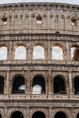 Naklejka premium Arches archictecture of Colosseum (Colosseo) exterior with clouds and sky. Rome, Italy.