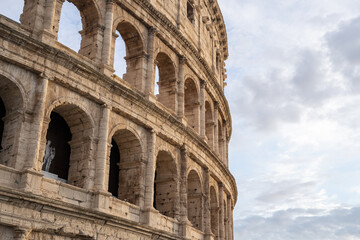 Fototapeta premium Arches archictecture of Colosseum (Colosseo) exterior with clouds and sky. Rome, Italy.