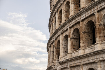 Arches archictecture of Colosseum (Colosseo) exterior with clouds and sky. Rome, Italy.
