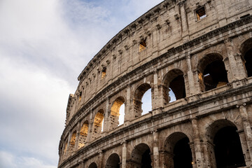 Fototapeta premium Arches archictecture of Colosseum (Colosseo) exterior with clouds and sky. Rome, Italy.