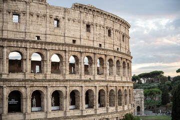 Fototapeta premium Arches archictecture of Colosseum (Colosseo) exterior with clouds and sky. Rome, Italy.