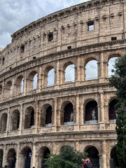 Obraz premium Arches archictecture of Colosseum (Colosseo) exterior with clouds and sky. Rome, Italy.