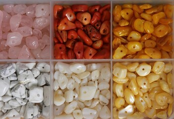 Colorful gemstone beads in a container.