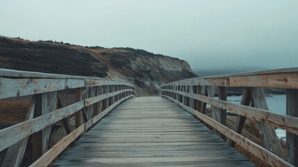 Obraz premium Wooden Bridge Leading To Misty Coastal Cliffs
