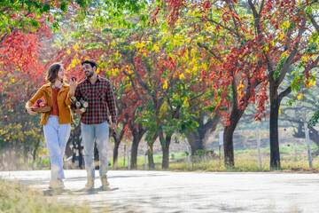 young caucasian family,a female holding axe,a man carrying firewood while walking home after working in farm ,concept of seasonal harvesting in autumn