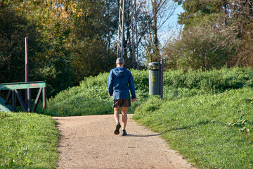 Man walking through a green park on a sunny day celebrating walk in the park day