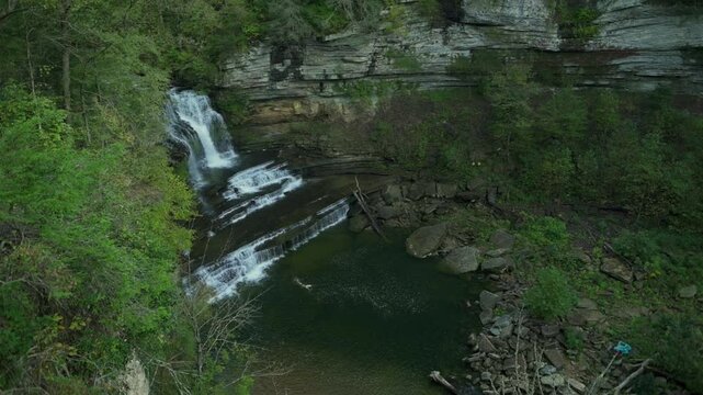 stunning waterfall cascading over rocky cliffs into clear pool surrounded by lush green trees at Cummins Falls State Park, USA, showcasing beauty of nature waterfall Cummins Falls State Park