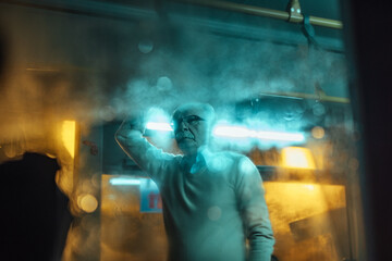 Man standing inside a foggy bus at night