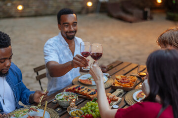 Toasting with red wine at a backyard dinner party