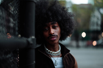 Young man with afro hairstyle posing in an urban setting