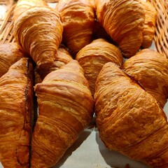 Freshly baked golden croissants stacked neatly.