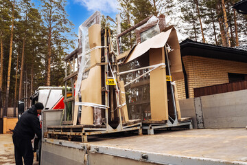 Pallets loaded with aluminum and plastic windows being delivered in a forested area