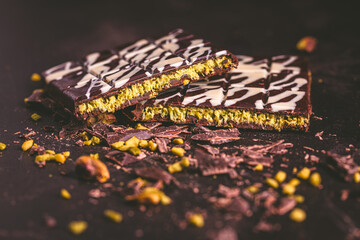 Dubai Chocolate bar with green kadayif and pistachio spread on brown background