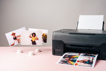 Modern laser printer printing color photos of women close up