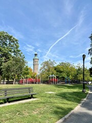 Naklejka premium Park bench and playground in front of Highbridge Water Tower in Harlem