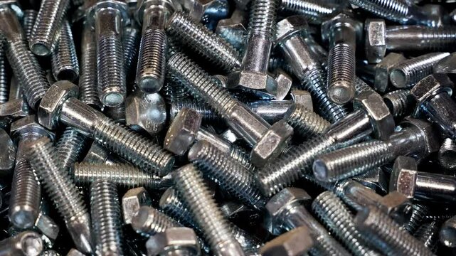 A bunch of new and shiny screws, destined for industrial use. Pile of fastener with hexagon head for wrench.