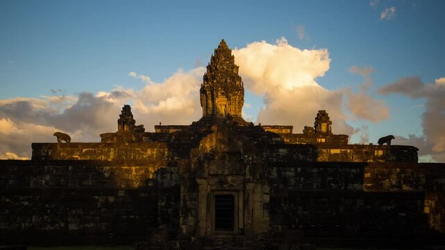 Bakong, Angkorian pyramid temple with golden clouds erupting during sun set.