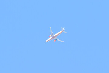 A large airplane is flying through a clear blue sky