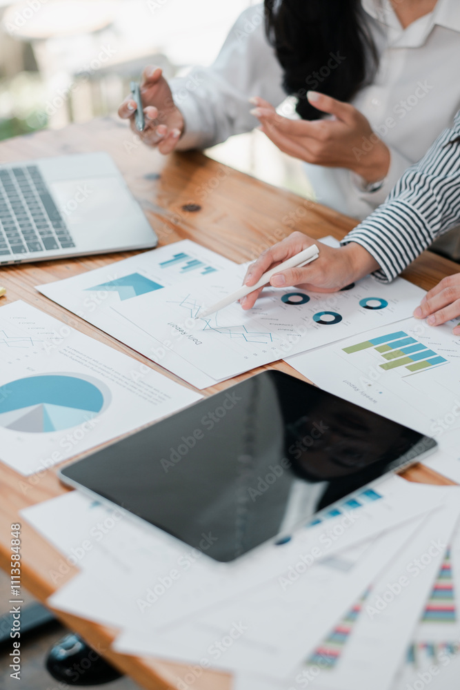 Aufkleber close-up of hands working on financial charts and graphs with digital devices on a wooden desk in a 