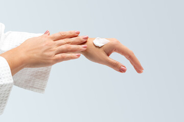 A white smear of body smoothing cream on woman's hand