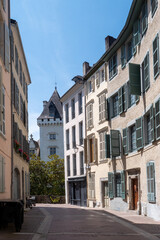 Narrow street with a castle of Henry VI in the background. The street is lined with buildings and...