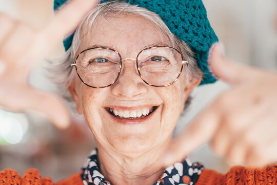 Portrait of attractive carefree smiling senior woman wearing eyeglasses gesturing with hands, looking at camera