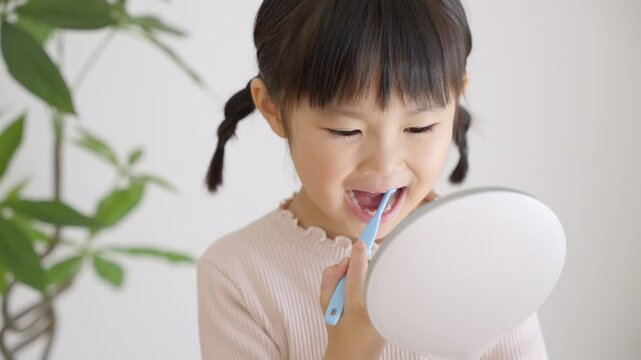 歯ブラシで歯磨きする子供