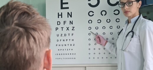 Ophthalmologist checking eyesight of teenage boy