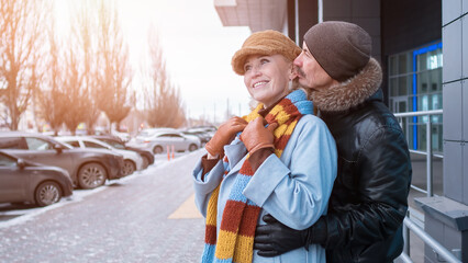 Happy senior couple embracing outdoors in winter city