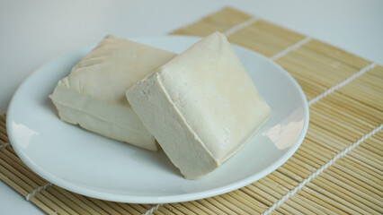 Two blocks of white tofu on a white plate
