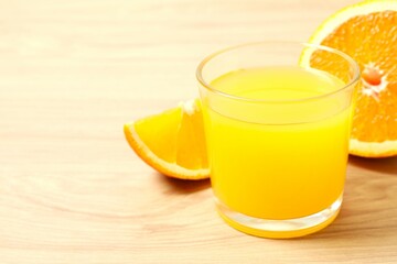 Glass of freshly squeezed orange juice on the table with citrus fruits